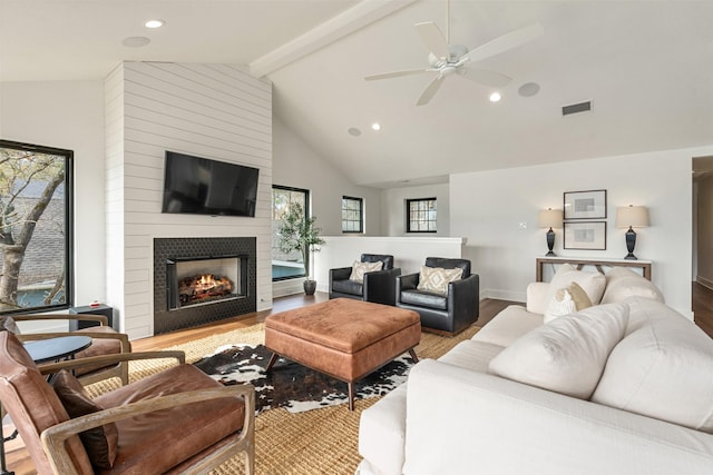 living room with a fireplace, vaulted ceiling with beams, light hardwood / wood-style flooring, and ceiling fan