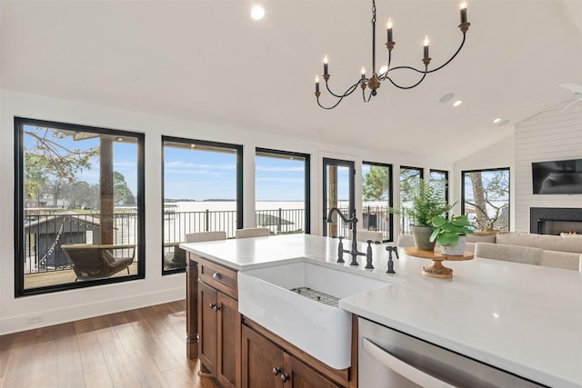 kitchen featuring lofted ceiling, an inviting chandelier, sink, hanging light fixtures, and dark hardwood / wood-style flooring