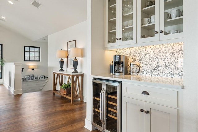 bar with backsplash, white cabinets, dark hardwood / wood-style floors, wine cooler, and lofted ceiling