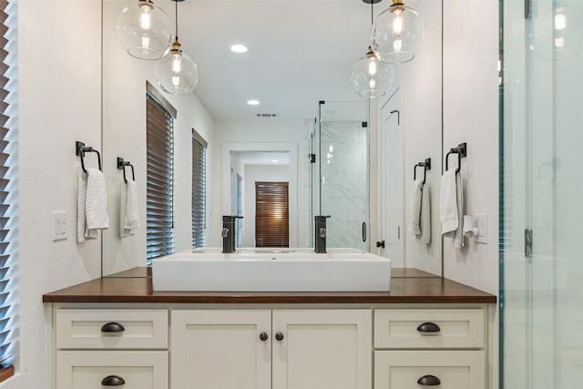 bathroom with vanity and a shower with door