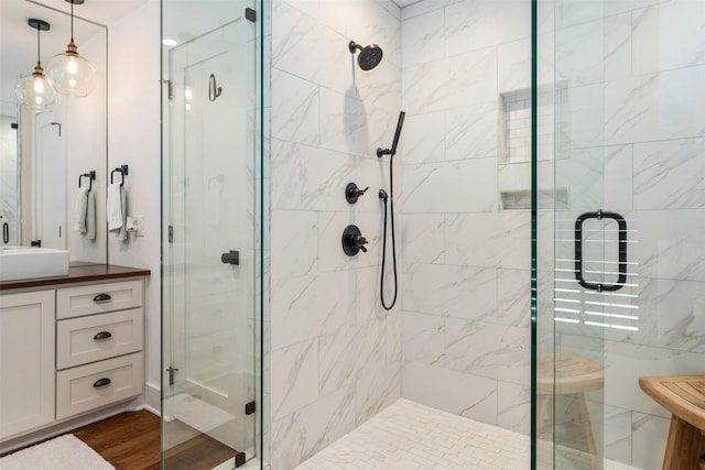 bathroom featuring hardwood / wood-style flooring, vanity, and walk in shower