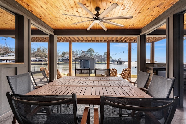 sunroom / solarium with ceiling fan, a water view, and wooden ceiling