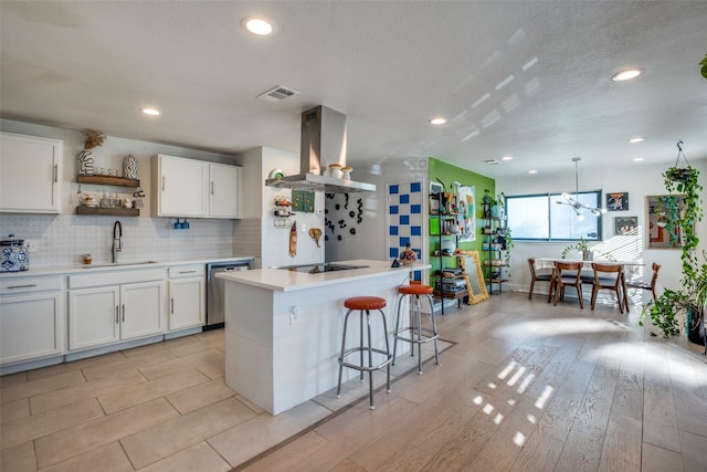 kitchen with island range hood, white cabinetry, a center island with sink, and sink