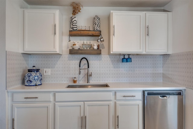 kitchen with stainless steel dishwasher, backsplash, white cabinetry, and sink