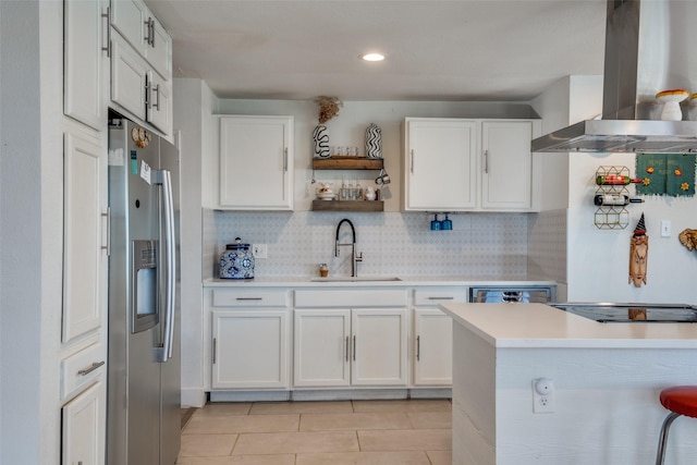 kitchen with stainless steel fridge, sink, white cabinetry, and wall chimney range hood