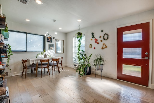 dining area featuring light hardwood / wood-style floors and a notable chandelier