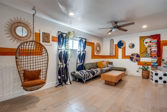 living room featuring ceiling fan and light hardwood / wood-style floors