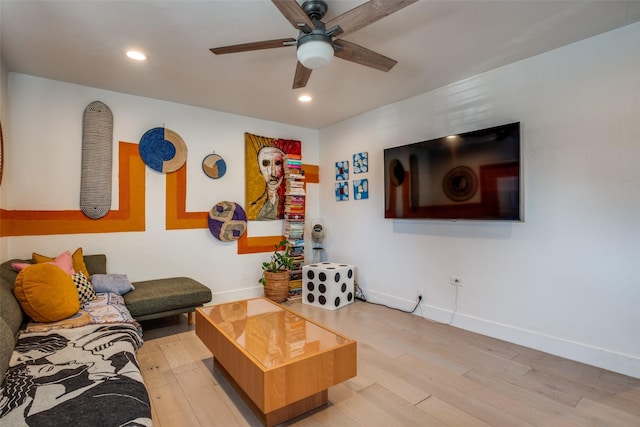 living room with ceiling fan and light hardwood / wood-style flooring