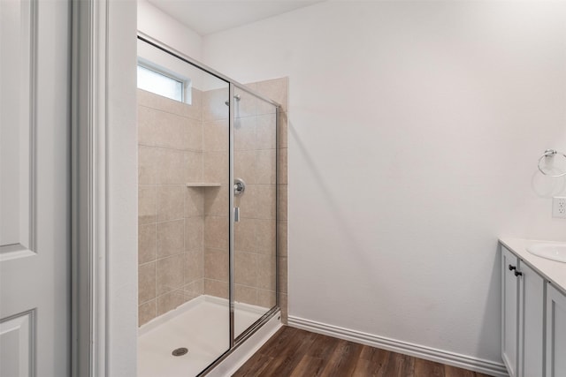 bathroom with wood-type flooring, vanity, and walk in shower