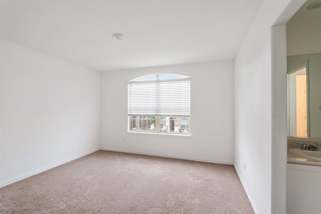 carpeted spare room featuring sink