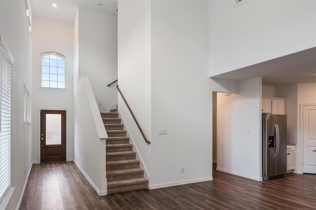 foyer with a towering ceiling and dark hardwood / wood-style flooring