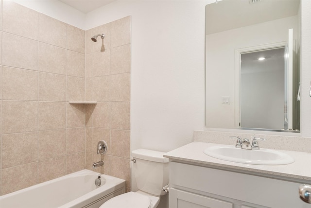 full bathroom with tiled shower / bath, vanity, and toilet