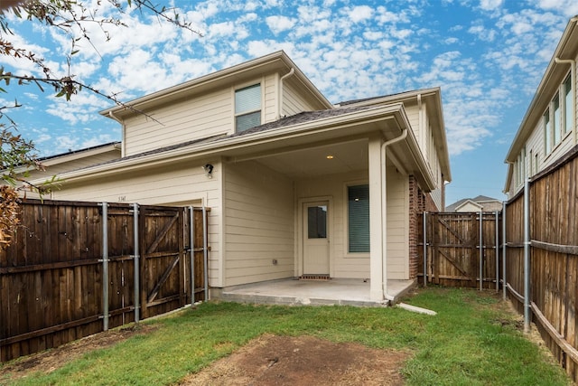 rear view of property featuring a patio and a yard