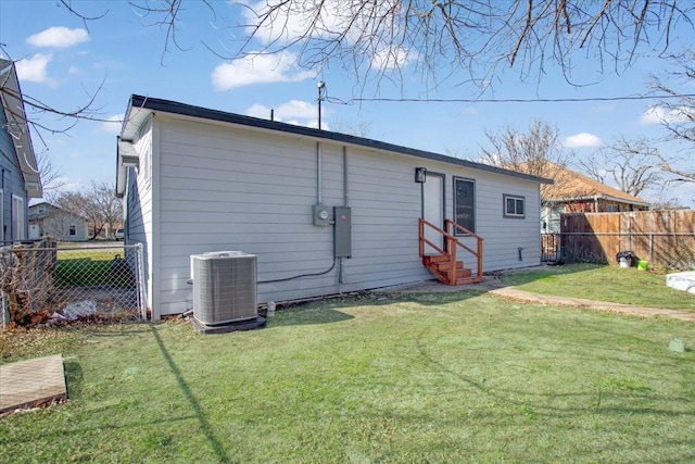 back of house featuring a yard and central AC