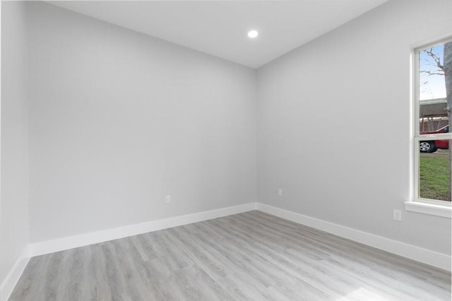 spare room with plenty of natural light and light hardwood / wood-style flooring