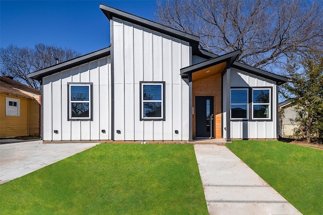 modern home featuring a front lawn and a patio area