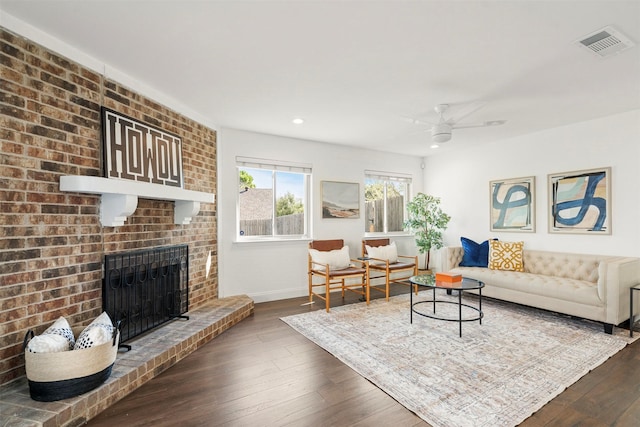 living room with a fireplace, dark hardwood / wood-style floors, and ceiling fan