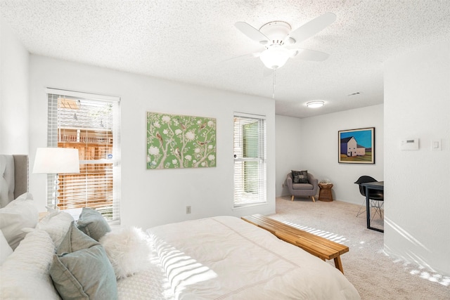 carpeted bedroom with ceiling fan and a textured ceiling