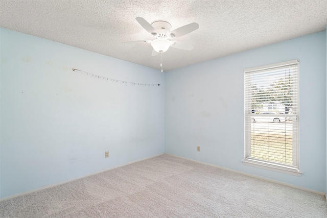 spare room with carpet, plenty of natural light, ceiling fan, and a textured ceiling