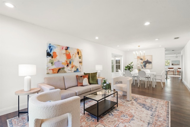 living room with a chandelier and dark wood-type flooring