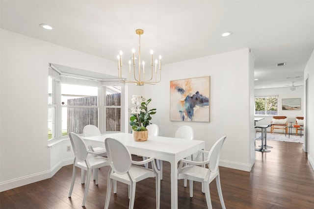 dining area with dark hardwood / wood-style flooring and a notable chandelier