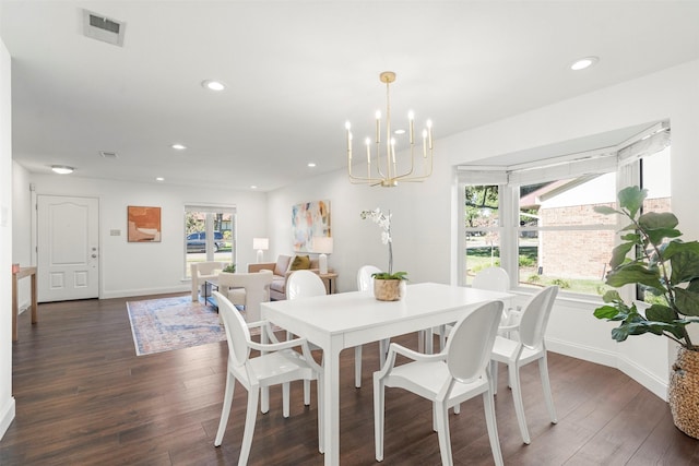 dining area featuring dark wood-type flooring, an inviting chandelier, and a healthy amount of sunlight