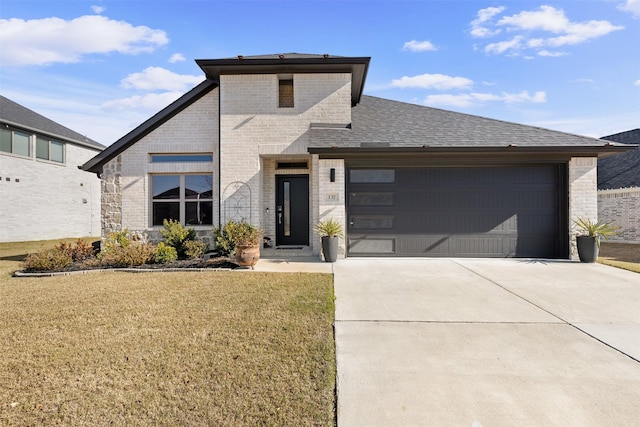 view of front of property featuring a front yard and a garage