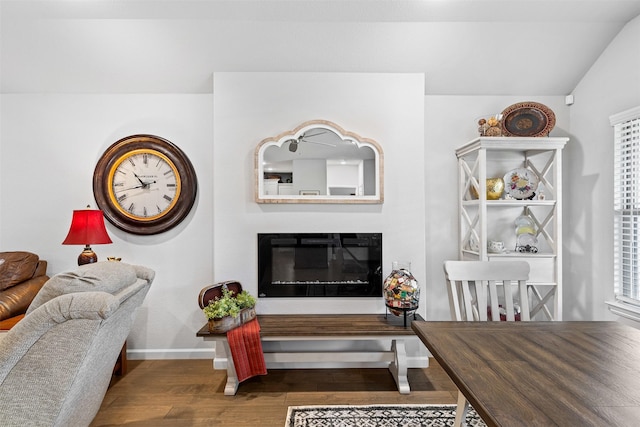 living room featuring dark wood-type flooring and vaulted ceiling