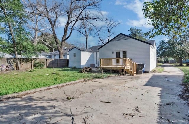 rear view of house featuring a deck and a lawn