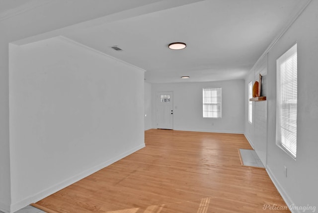 entrance foyer featuring ornamental molding and light hardwood / wood-style flooring