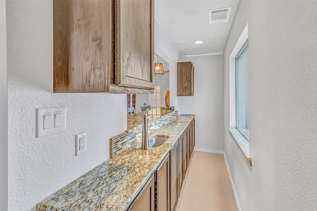 kitchen with light stone counters and sink