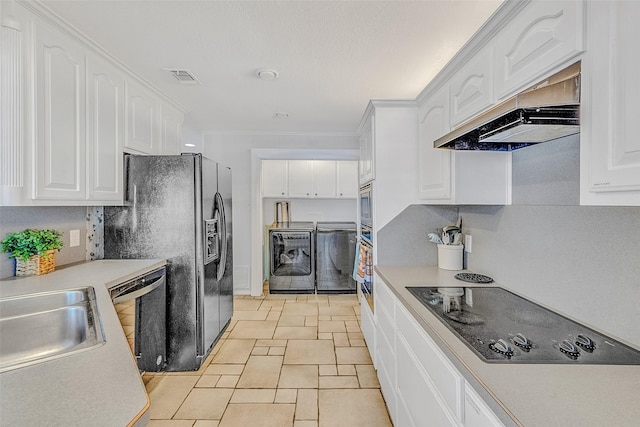 kitchen featuring washer and clothes dryer, premium range hood, black appliances, light tile patterned floors, and white cabinetry