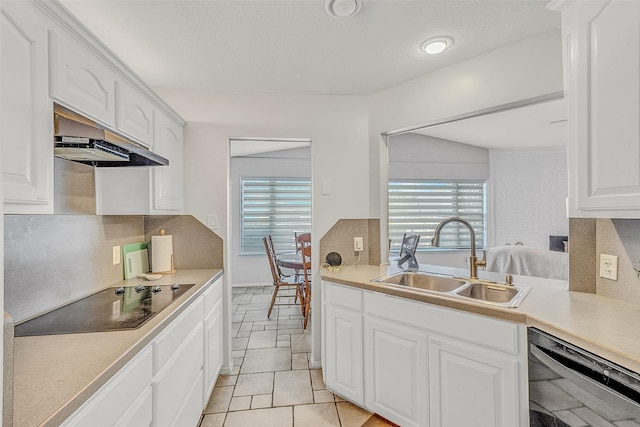 kitchen with decorative backsplash, white cabinetry, sink, and black appliances