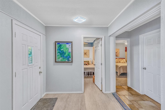 foyer featuring crown molding, a textured ceiling, and light hardwood / wood-style floors