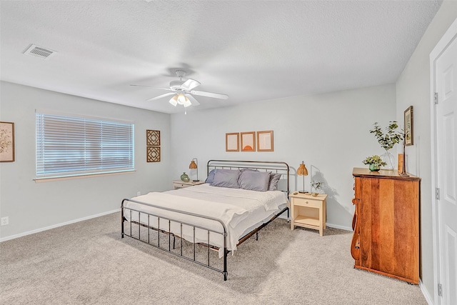 carpeted bedroom with ceiling fan and a textured ceiling