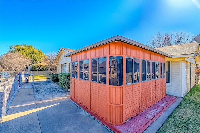 view of home's exterior featuring a sunroom and a patio