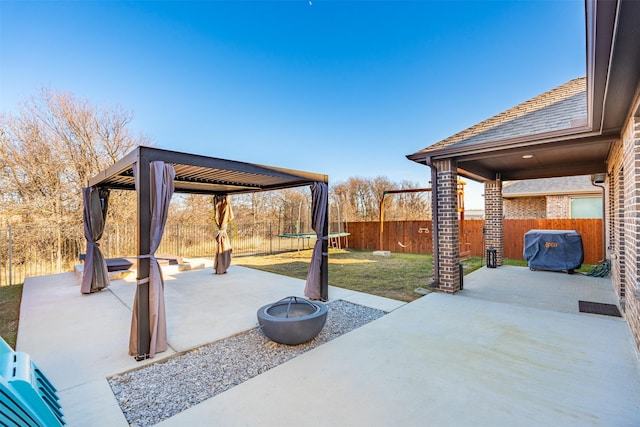 view of patio / terrace featuring a gazebo, an outdoor fire pit, a trampoline, and a fenced backyard