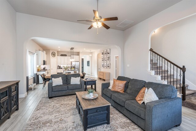 living room with light wood-type flooring and ceiling fan