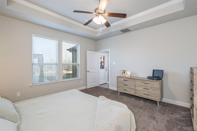 bedroom featuring a tray ceiling, crown molding, visible vents, dark carpet, and baseboards