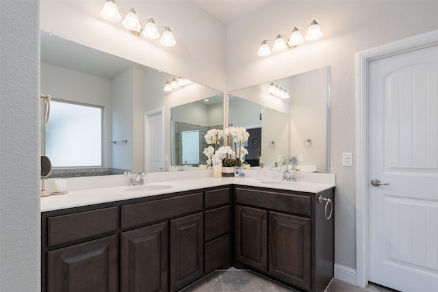 bathroom featuring double vanity, a shower stall, and a sink