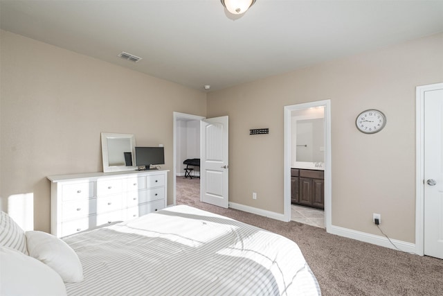 bedroom with baseboards, ensuite bath, visible vents, and light colored carpet