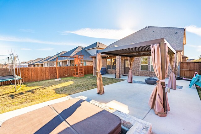 view of patio with a fire pit and a trampoline