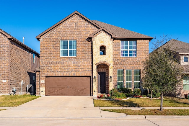 traditional-style house featuring stone siding, brick siding, and driveway