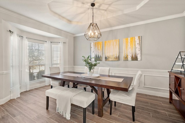 dining space with a notable chandelier and a raised ceiling