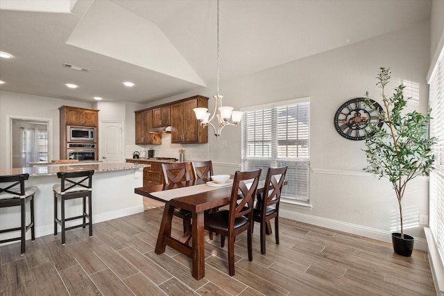 dining room with vaulted ceiling and a notable chandelier