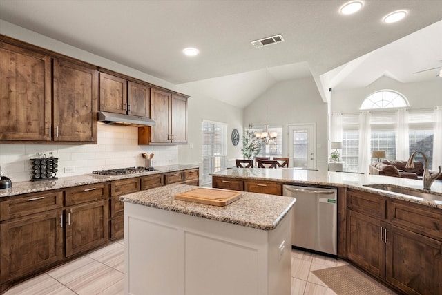 kitchen featuring vaulted ceiling, tasteful backsplash, sink, light tile patterned floors, and stainless steel appliances