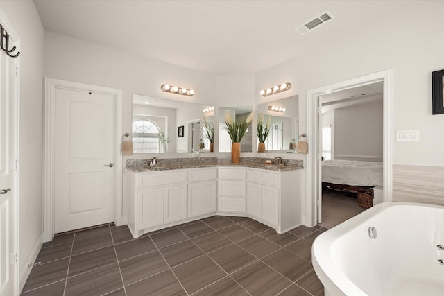 bathroom with vanity, a tub to relax in, and tile patterned flooring