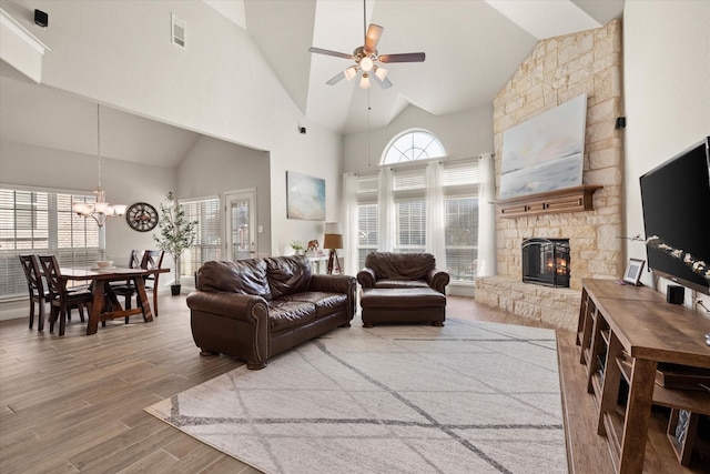 living room with hardwood / wood-style floors, plenty of natural light, ceiling fan with notable chandelier, and a fireplace