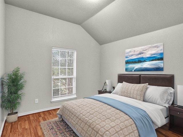 bedroom featuring vaulted ceiling and wood-type flooring