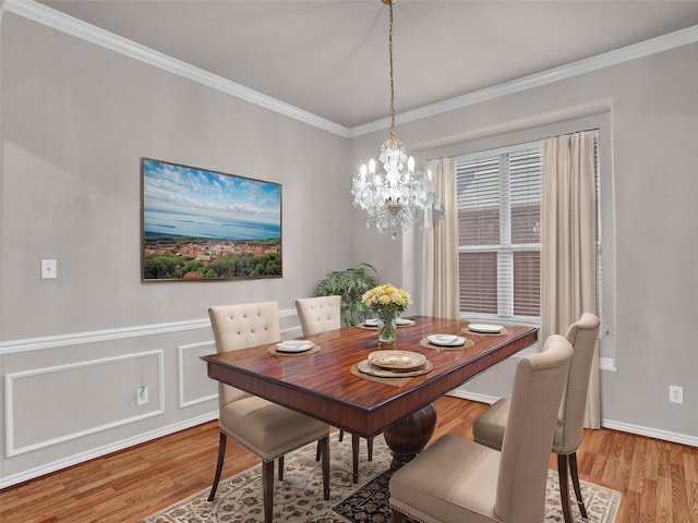 dining room featuring light hardwood / wood-style flooring, ornamental molding, and a notable chandelier